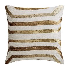 a gold and white striped pillow with sequins on the front, along with a matching throw pillow