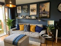 a living room filled with furniture and pictures on the wall above it's windows