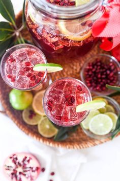 two glasses filled with pomegranate and limes