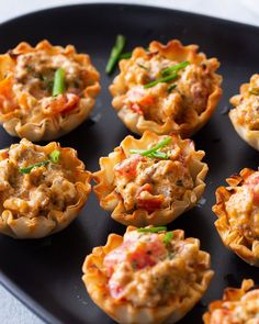 small cups filled with food sitting on top of a black plate