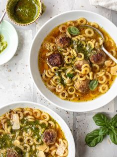 two bowls of pasta soup with meatballs and pesto