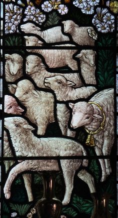 a stained glass window with sheep and flowers