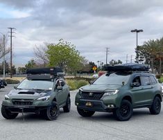 two cars are parked in a parking lot with their lights on and one is green