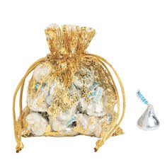 a gold bag filled with lots of white and blue candies next to a silver cone