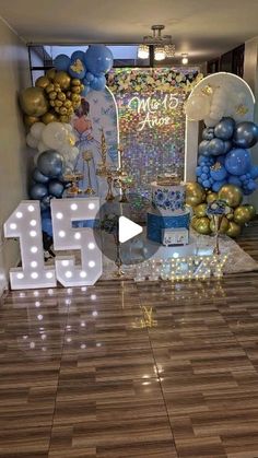 a room decorated with balloons and lights for a 65th birthday party in blue, gold and white