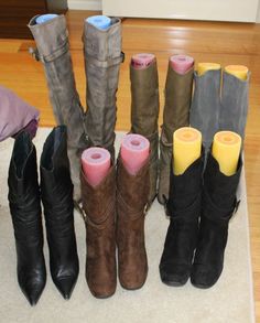 several pairs of boots are lined up on the floor in front of a pile of blankets