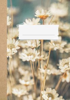 a bunch of flowers that are in front of a brown paper with a white tag on it