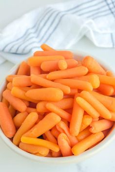 a white bowl filled with carrots on top of a table