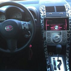 the interior of a car with an animal print dash board and steering wheel cover on