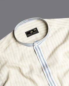 Introducing the Wheatfield Beige and White Striped Luxurious Linen Designer Shirt, where sophistication meets comfort. Crafted from premium linen fabric blended with pure cotton, this trendy piece comes with a concealed placket, mandarin collar, and vertical striped design. Whether it's a casual outing or a formal affair, this shirt ensures you make a statement with every step. Fused collar and cuffs, collar stand and flat felled side seams provide structure and stability to all our shirts. Line Luxury Shirt With Striped Cuffs For Daywear, Luxury Relaxed Fit Shirt With Striped Collar, Luxury Pinstripe Shirt With Striped Cuffs, Luxury Striped Cotton Dress Shirt, Casual Linen Shirt, Luxury Cotton T-shirt With Striped Collar, Shoulder Shirts, Vertical Stripes, Luxury Linen