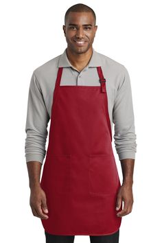 a man wearing an apron and smiling at the camera with his hands in his pockets