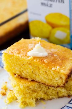 two pieces of cornbread on a blue and white plate with a carton of marshmallows in the background