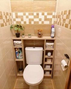 a toilet in a small bathroom with tiled walls