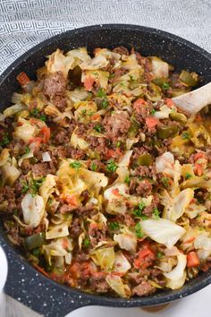 a skillet filled with cabbage, meat and vegetables