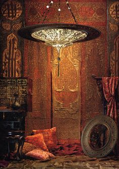 an ornate chandelier hangs from the ceiling in a room with red and gold decor