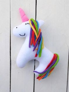 a stuffed unicorn is hanging on the wall