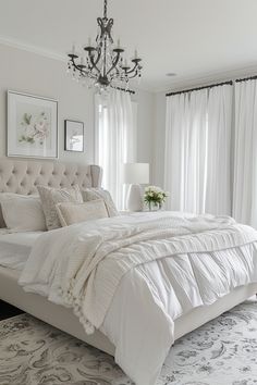 a bedroom with a large bed and chandelier