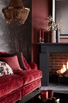 a living room filled with furniture and a fire place in front of a brick wall