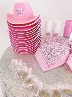 a table topped with lots of pink plates and cups