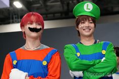 two young men with fake mustaches on their faces are dressed as mario and luigi