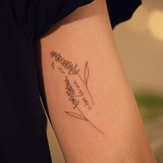 a woman with a tattoo on her arm that says, let the wildflowers bloom