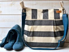 a purse and pair of blue shoes sitting on a white table next to a wooden wall