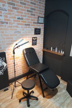 a room with a brick wall and a black chair next to a microphone on a stand