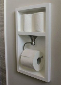 two rolls of toilet paper are hanging on the wall in this bathroom storage unit that is built into the wall