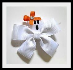 a close up of a bow with a ghost on the front and an orange cross on the back