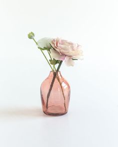 a pink vase filled with flowers on top of a white table