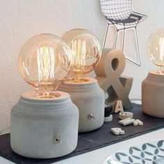 three light bulbs sitting on top of a table next to a plate with letters and numbers