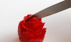 a knife is cutting through the center of a strawberry