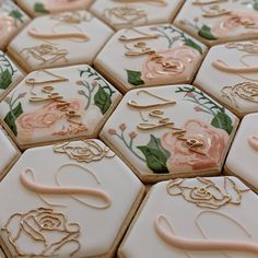 many decorated cookies are arranged in rows on top of each other with gold letters and flowers