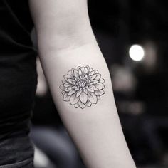 a woman's arm with a flower tattoo on the left side of her arm