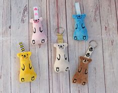 four keychains with different designs on them sitting on a wooden table next to each other