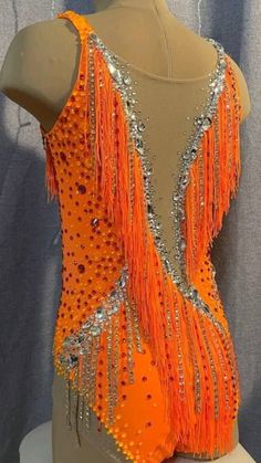 a mannequin with an orange top and silver sequins on it's back