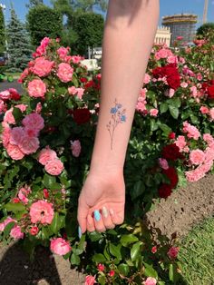 a woman's foot with a flower tattoo on her left ankle and pink flowers in the background