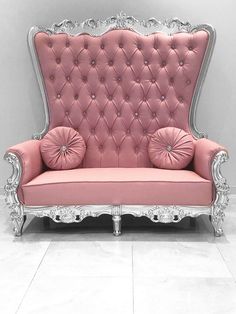 a pink couch sitting on top of a white tile floor next to a gray wall