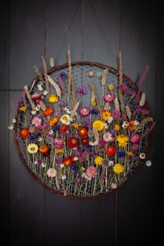 a bunch of flowers that are sitting in a basket on the wall next to a door