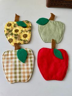 three apple appliques are sitting on a table