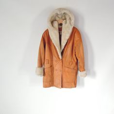 "Brand: Wilsons the Leather Experts 1990's Vintage Caramel Color brown leather Huge Acrylic pile Faux Fur lined hood, shawl collar and wrists The faux fur is a heavy thick pile Double breasted Deep V neck design has pockets missing belt if there was one (has loops) Some fading and a small pea size stain on one arm and the overall look is a bit weathered but looks so cool this way. Don't buy if you are expecting perfection. The pile faux fur on the wrists is a bit grungy and could use a dry clean Retro Leather Outerwear For Winter, Retro Leather Winter Outerwear, Vintage Leather Jacket For Cold Weather, Brown Leather Fur Coat With Faux Fur Lining, Vintage Leather Outerwear For Cold Weather, Brown Sheepskin Coat With Faux Fur Trim, Retro Brown Faux Fur Coat, Brown Vintage Fur Coat With Faux Fur Trim, Vintage Brown Fur Coat With Pockets