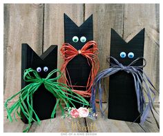 three black cats made out of paper and string