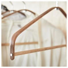 a pair of wooden clothes hangers in front of a white shirt