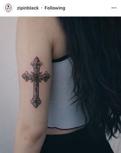 a woman with a cross tattoo on her arm