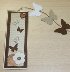 a bookmark with butterflies and flowers on it sitting on a table next to scissors