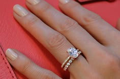 a close up of a person's hand with a diamond ring on their finger