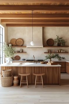 an open kitchen with wooden cabinets and counter tops, along with two stools in front of the island