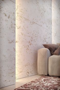 a white couch sitting next to a brown rug on top of a carpeted floor