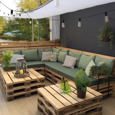 a couch and table made out of wooden pallets on a deck with lights strung above