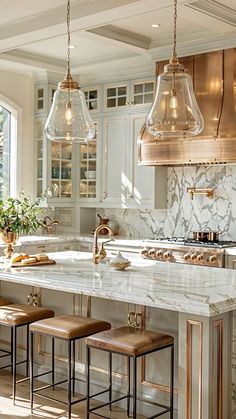 a kitchen with marble counter tops and stools in front of an island that has three lights hanging over it